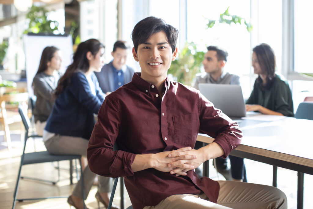 Professional sales intern seated in an open office.