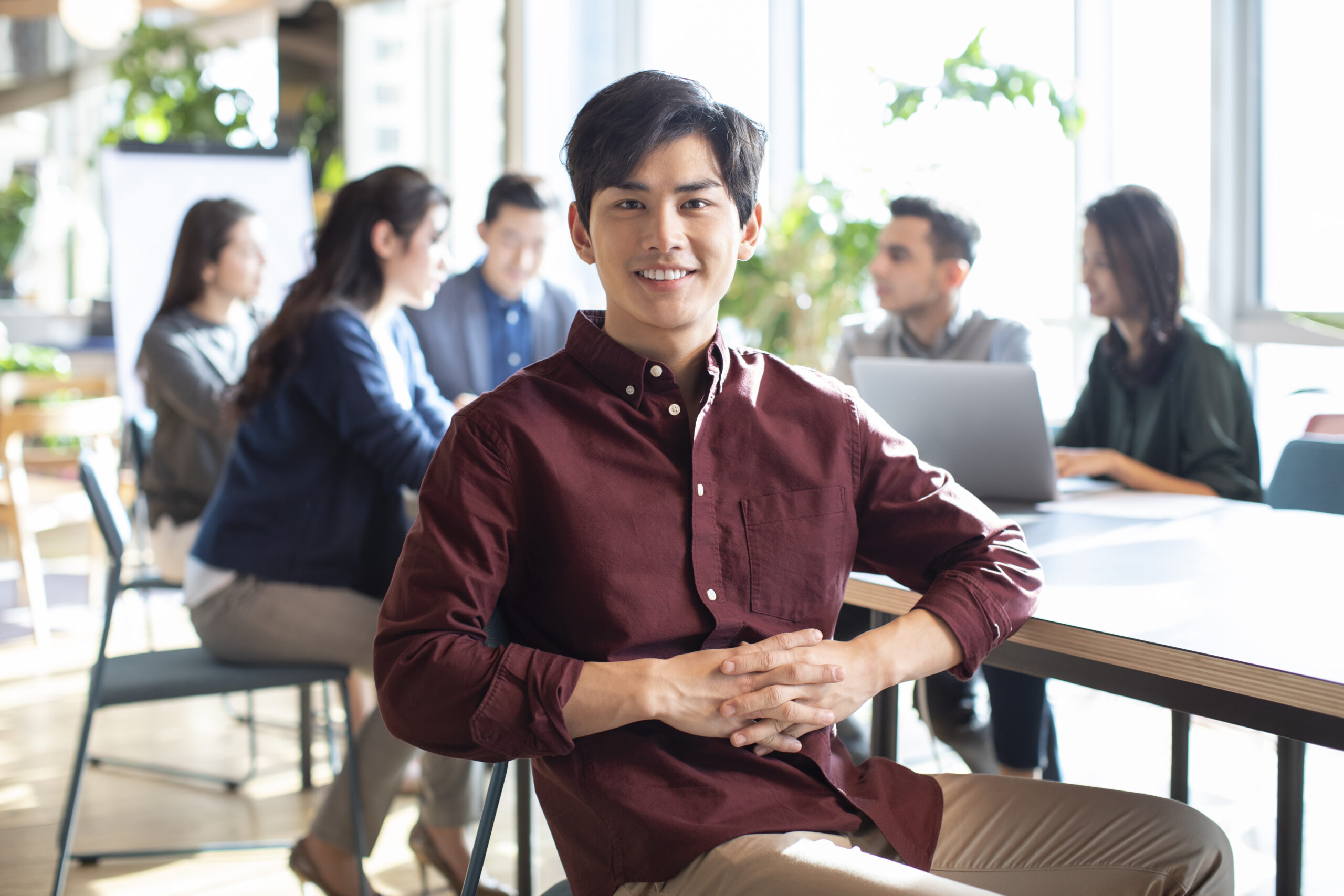 Professional sales intern seated in an open office.